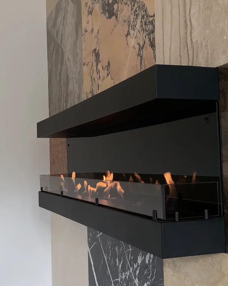 Чёрный навесной биокамин iVENGO Bensen Fireglass с горящей линией огня на мраморной стене