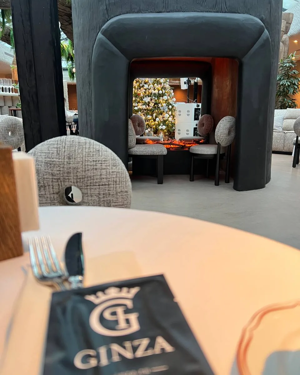 Вид на пещеру с паровым камином iVENGO из зала ресторана, на столе меню Ginza
